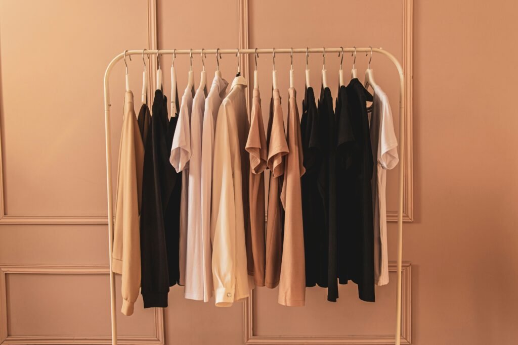 Minimalist capsule wardrobe with neutral-toned clothing on a simple rack