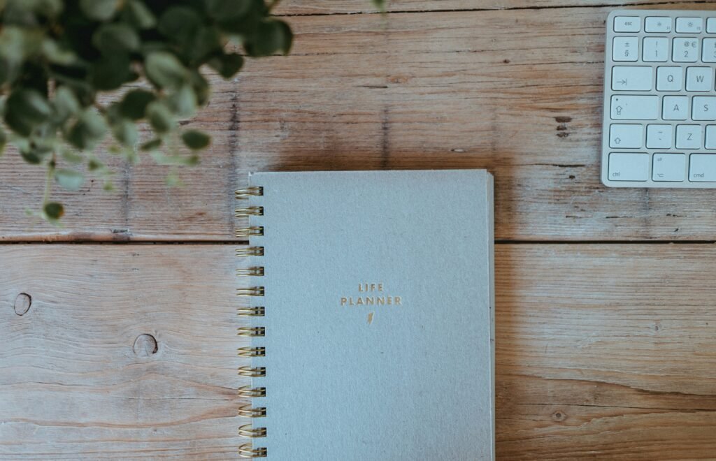Notebook and keyboard on wooden desk for planning tasks