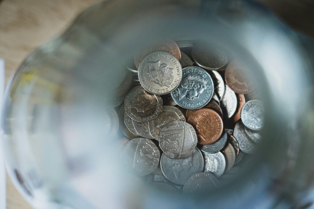 Jar filled with coins, symbolizing savings from cutting unnecessary expenses