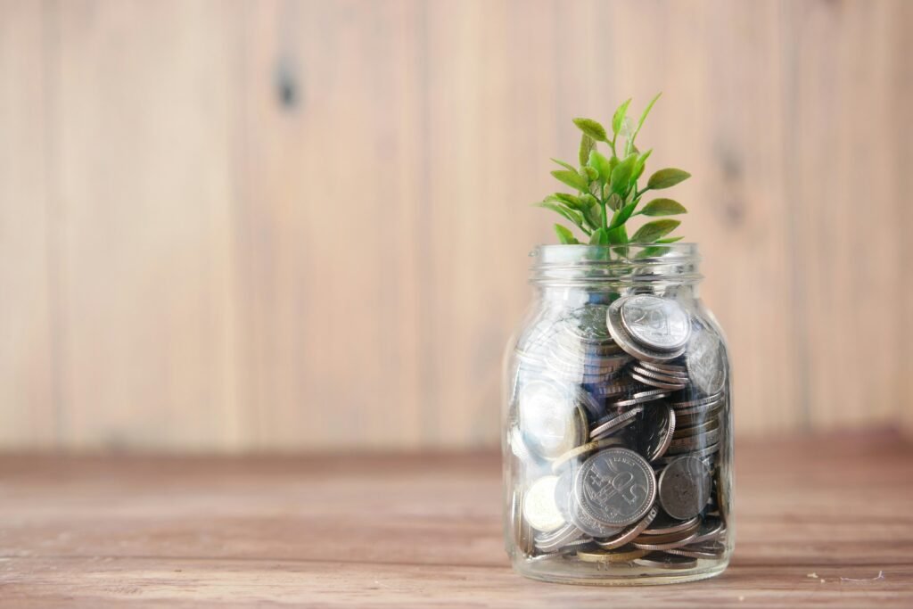 Plant sprouting from a jar of coins, representing financial growth