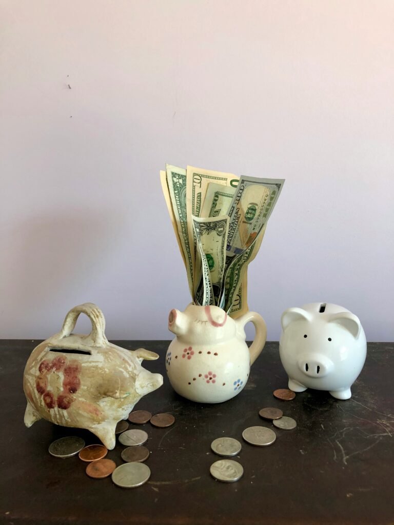 saving cash from side hustles — piggy banks and dollar bills showing small wins stacking up
