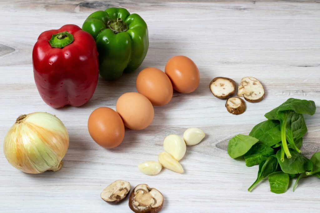 Budget-friendly pantry staples including eggs, beans, vegetables, and grains arranged on a table