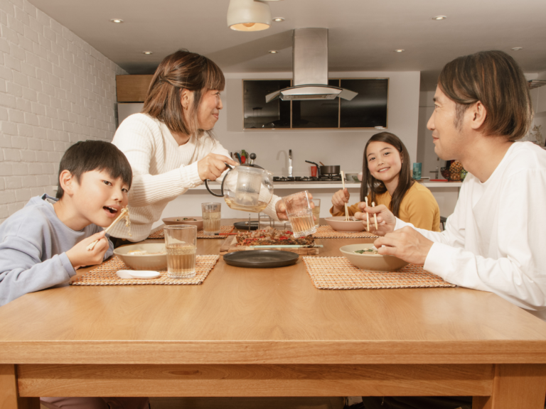 Family enjoying dinner together after completing their $50 meal plan challenge