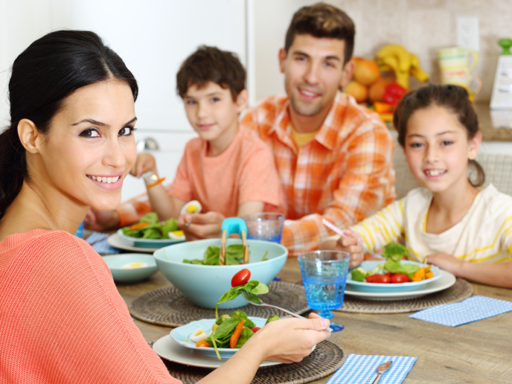 Happy family eating together after following a realistic $50 meal plan