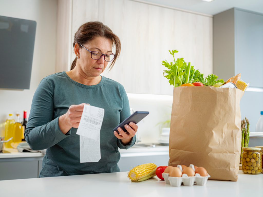 Person reviewing grocery receipt to stay within a $50 meal plan budget
