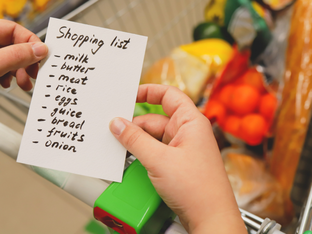 Hand holding a shopping list for weekly meal planning on a budget
