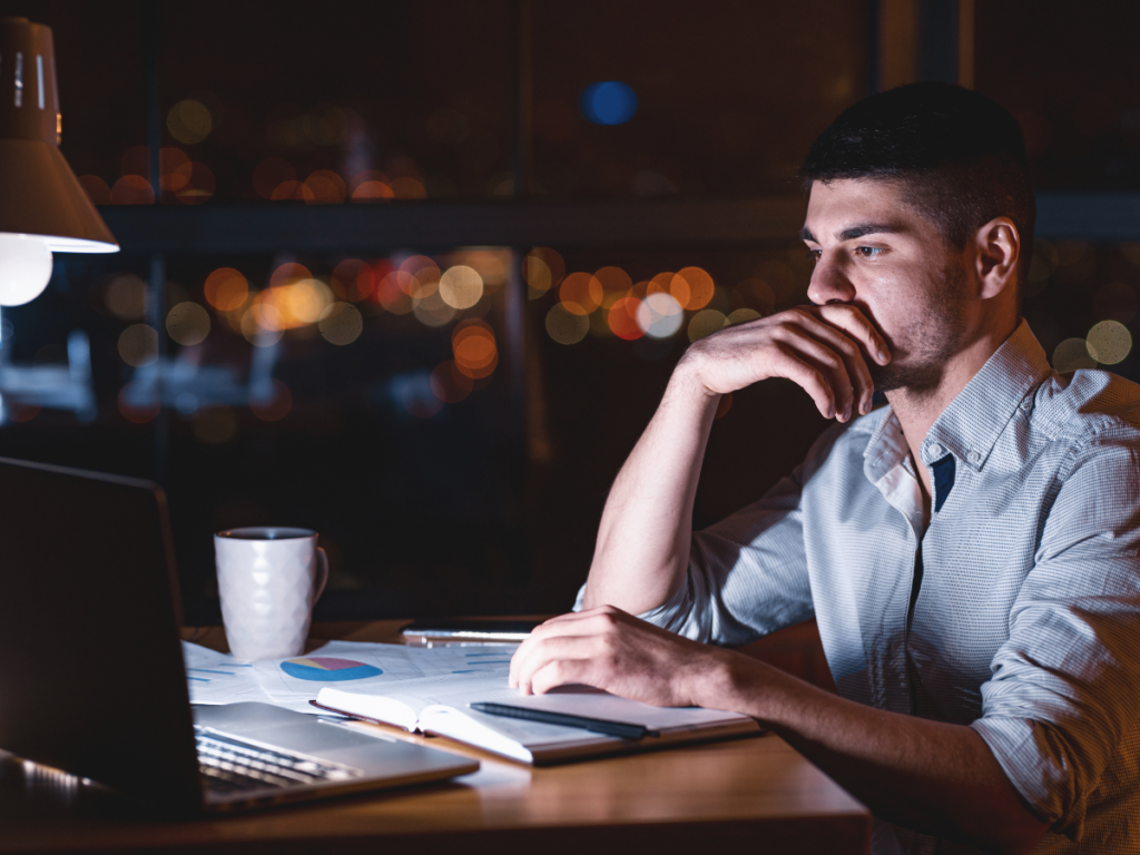 Side hustler working at night with digital tools to maintain a consistent and productive evening routine.