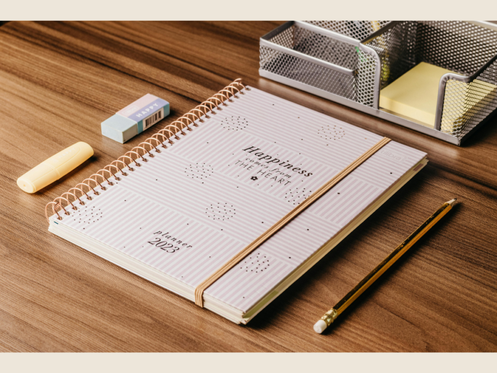 Organized planner and calculator on a minimalist desk representing a decluttered finance system and smarter money management.