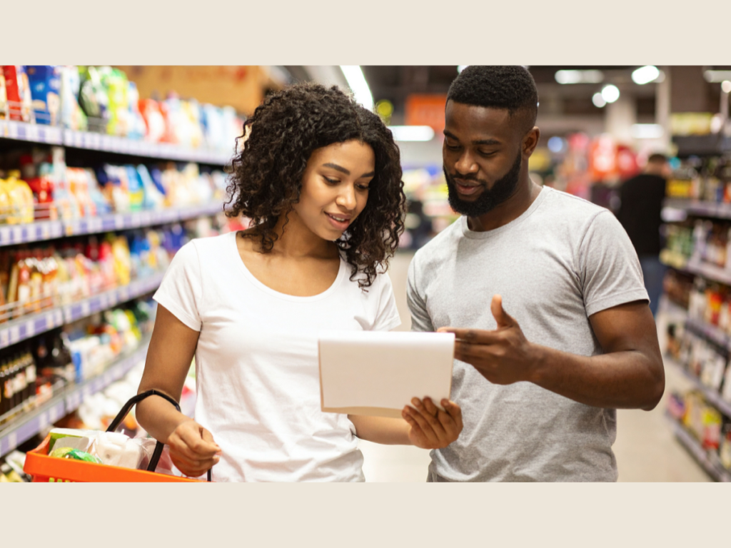 Couple checking a grocery list for freezer meal prep and meal planning on a weekend shopping trip.