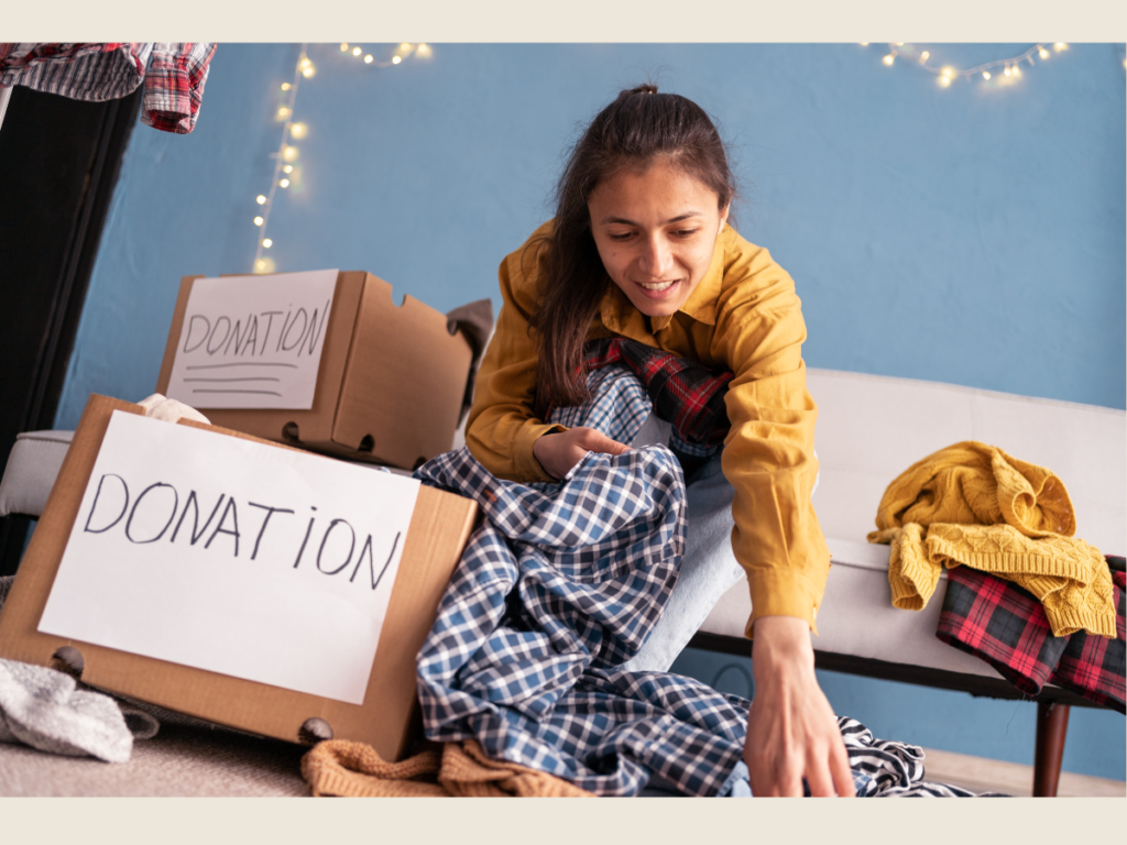Woman packing a donation box as part of minimalist living and decluttering routine.