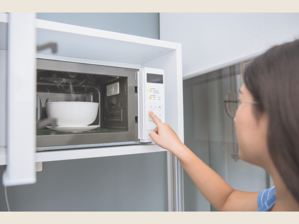 Person reheating freezer meals in the microwave for a quick, time-saving dinner after work.