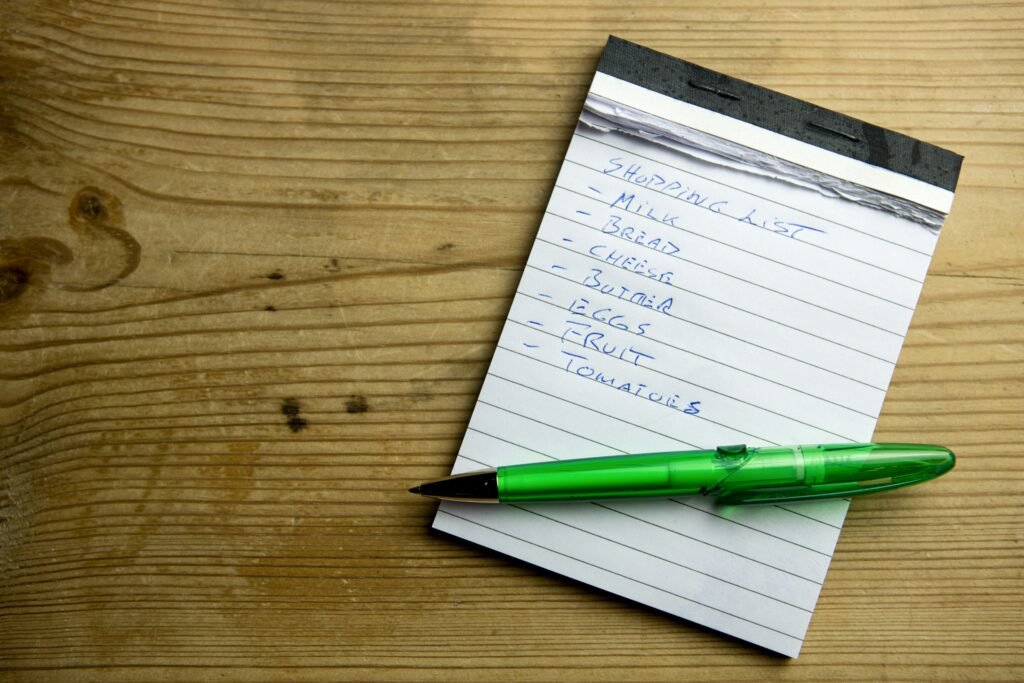 Flat lay of a weekly meal planning notebook with a handwritten grocery list