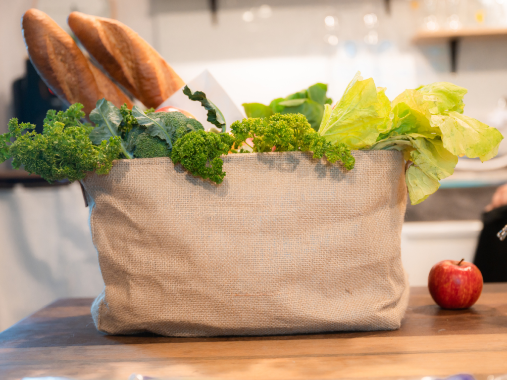 A half-full tote bag holding essential groceries, reflecting the simplicity of the one-bag challenge.